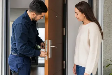 Chaveiro abrindo uma porta com ferramentas apropriadas, em Paranaguá.